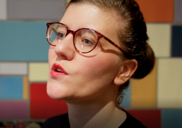 photo of a woman wearing glasses talking to the camera