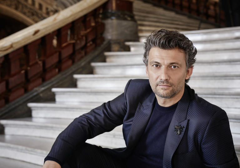 A portrait of Jonas sitting on some stairs