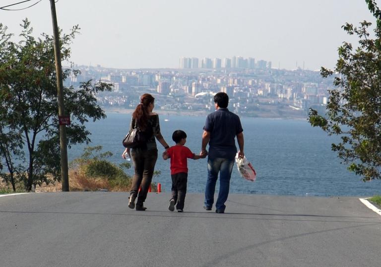 parents with their child between them holding both their hands 