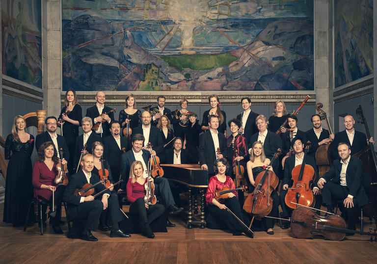 A portrait of the Norwegian Chamber Orchestra clutching their instruments