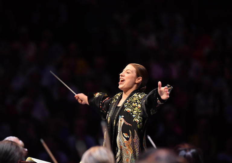 Dalia's arms outstretched as she conducts