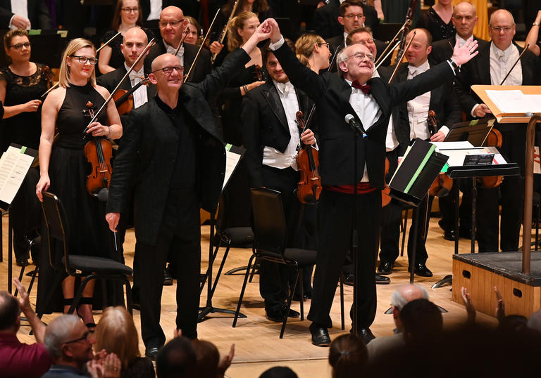 An image of Rutter and Chilcott jubilant, with their arms raised in salutation