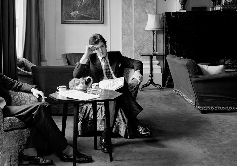 A black and white photograph of a well dressed, wealthy man looking despondent