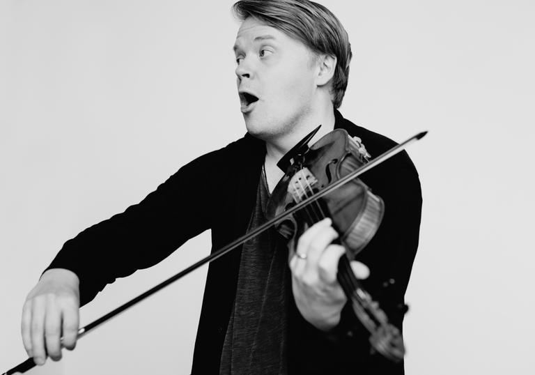An image of Pekka joyfully playing his violin 