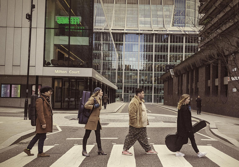 Four Guildhall students on zebra crossing in style of The Beatles' Abbey Road album