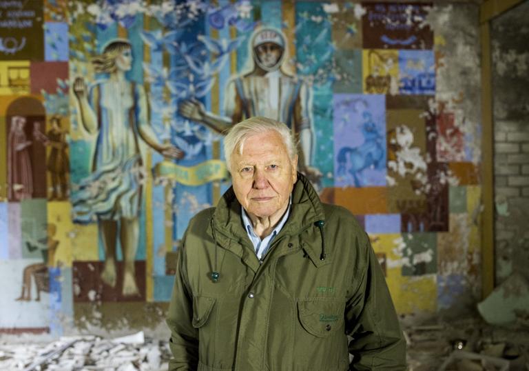 David Attenborough in front of a painted mural