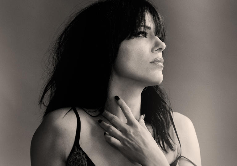 Imelda May looking to the left and holding her hand up to her neck
