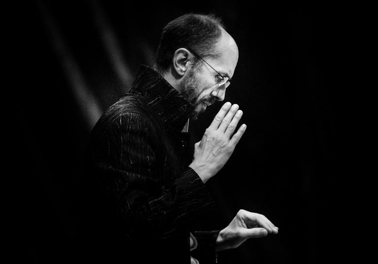 A portrait of Herve conducting in a serious manner