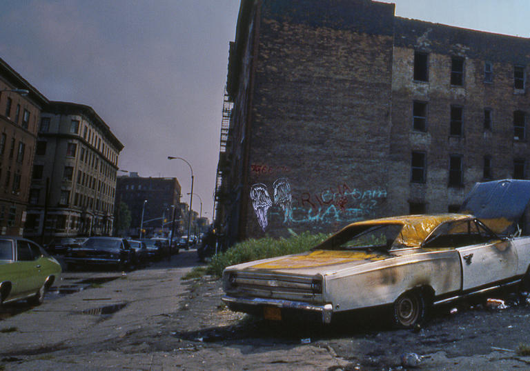 Shot of burnt out car on a bronx street corner