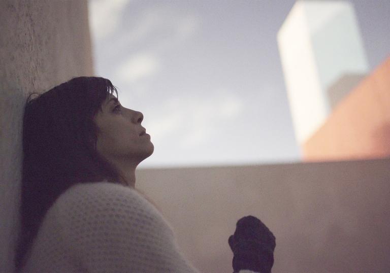 Woman sitting on the floor looking up at the sky