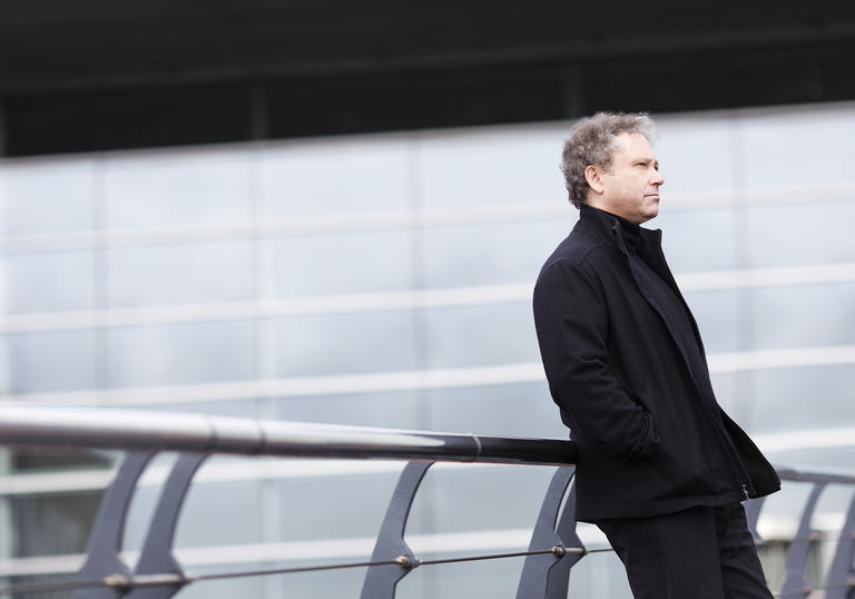 Richard Edgarr leaning on a bridge gazing into the middle distance