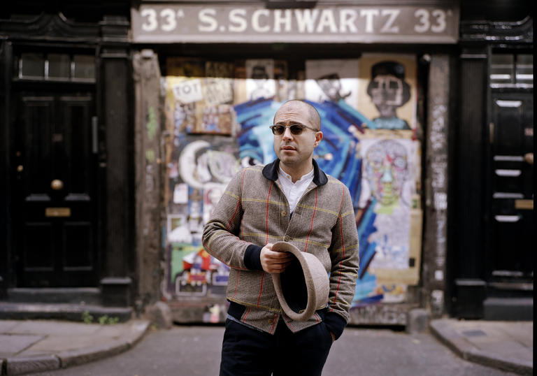 Mahan Esfahani in front of a graffiti wall