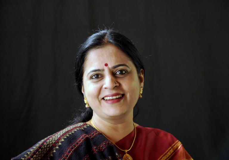 A headshot of Bharati Pratap smiling at the camera