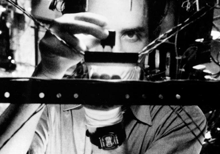 black and white photo of man staring at some machine