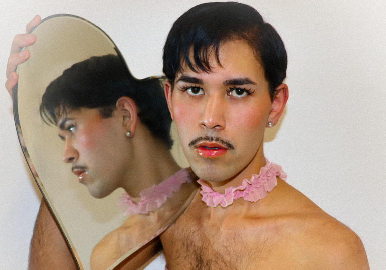 Radam Ridwan holding a heart shaped mirror