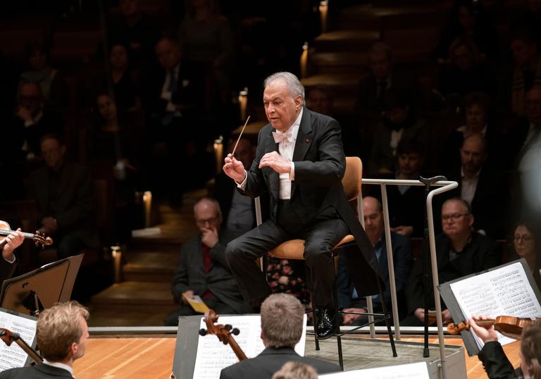 Zubin Mehta conducting the Berlin Philharmonic from a chair