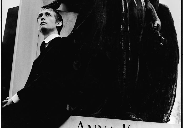 Neil Hannon leadning on a statue of an angel