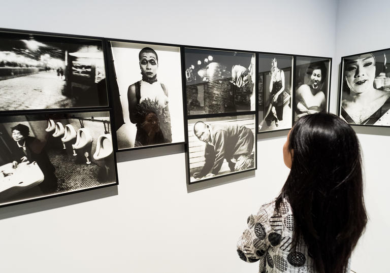 Woman looking at a wall filled with photographs