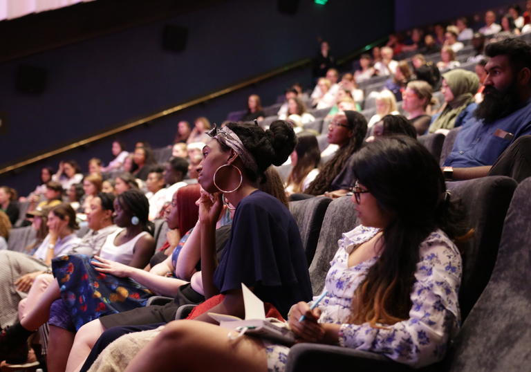 guests sitting in the cinema 1 listening to a speaker