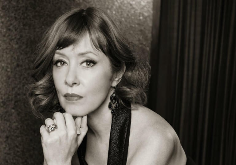 black and white photo of suzanne vega. resting her chin on her hand.