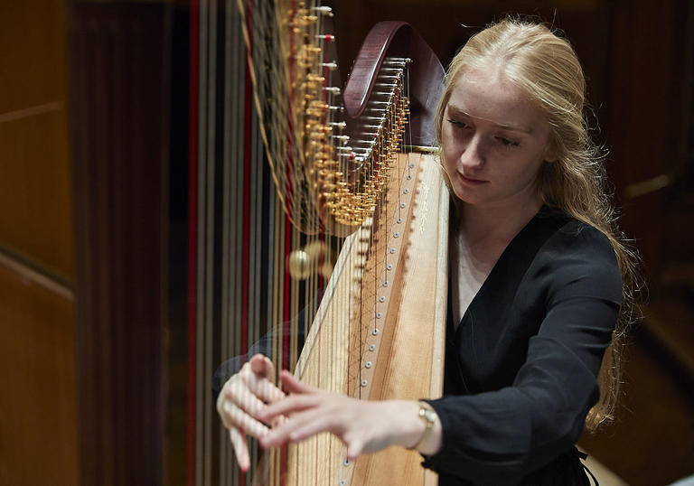 A Guildhall student playing the harp