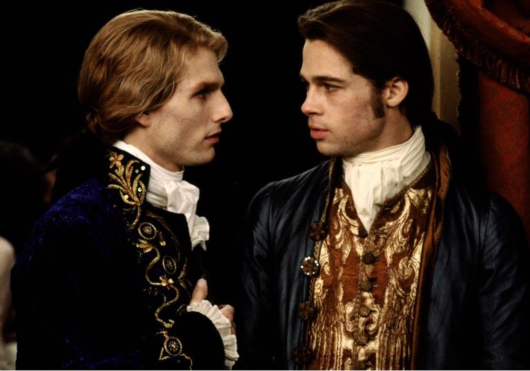 Tom Cruise and Brad Pitt look at each other in 19th century period costumes in Interview with the Vampire
