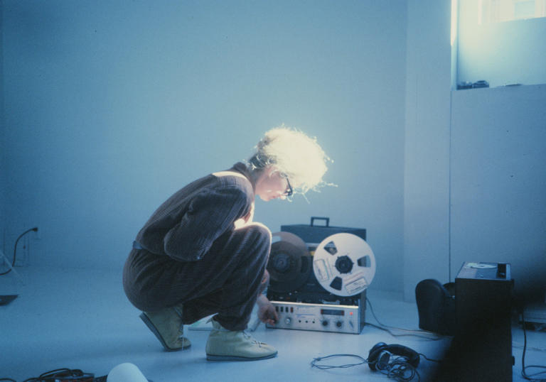 A woman kneels down in front of a recorder