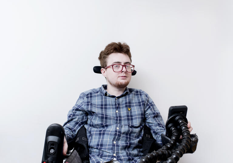 photo of a man with glasses in a wheelchair