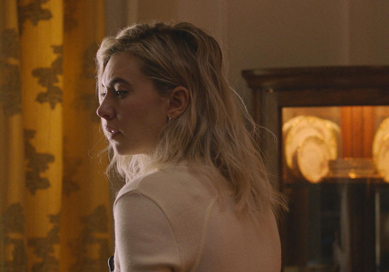 Vanessa Kirby sitting in a drab room