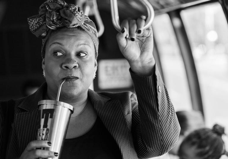 Radha Blank on a bus drinking