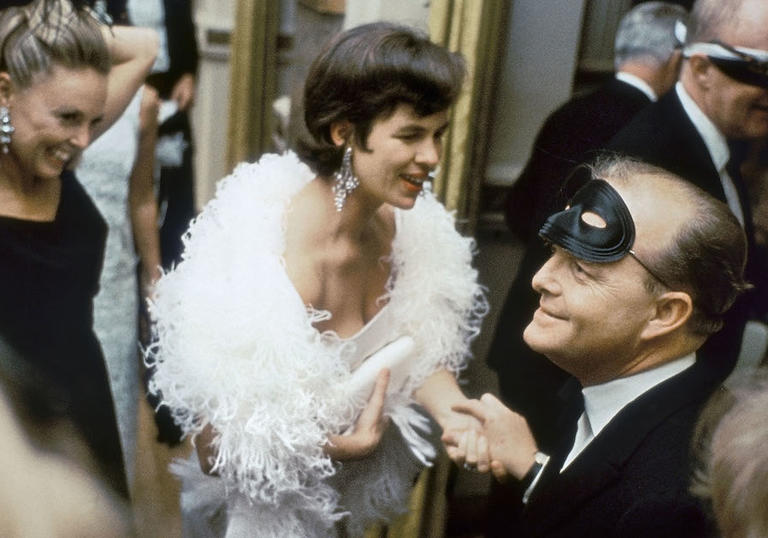 truman capote surrounded by women at a party