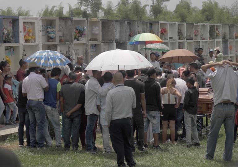 a group of people stand together with umbrellas