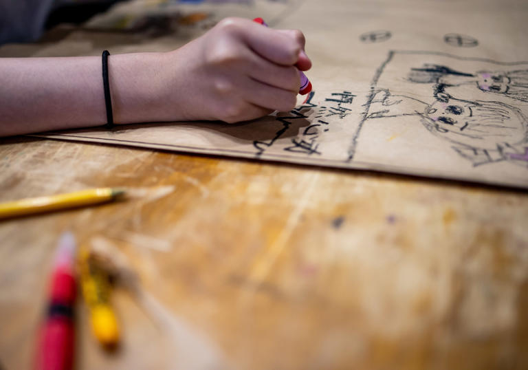 Child drawing on table in the Barbican Centre