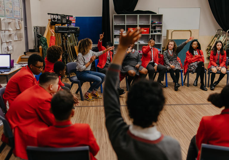 Group of students sitting with teacher in a classroom