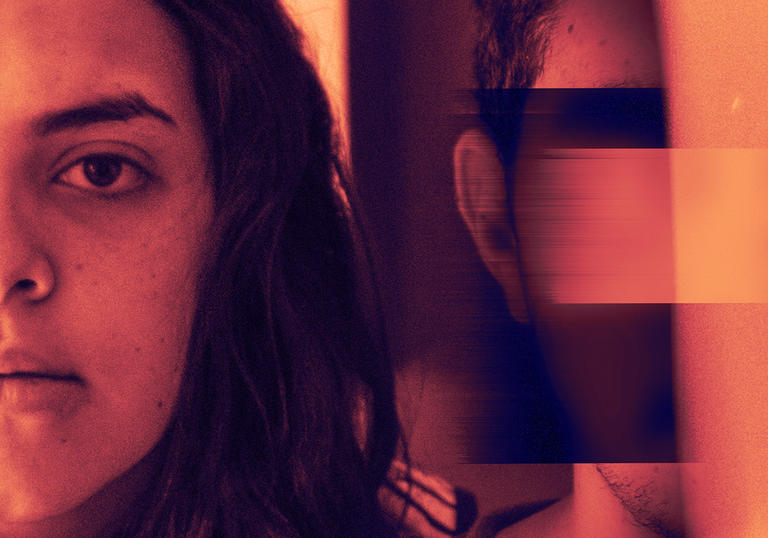 Close up image of woman staring into camera next to a man with a blurred face