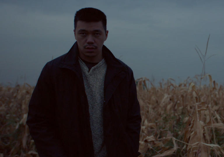 a man standing in a field of corn