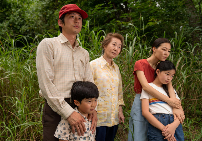 a family stand together with green landscape behind them