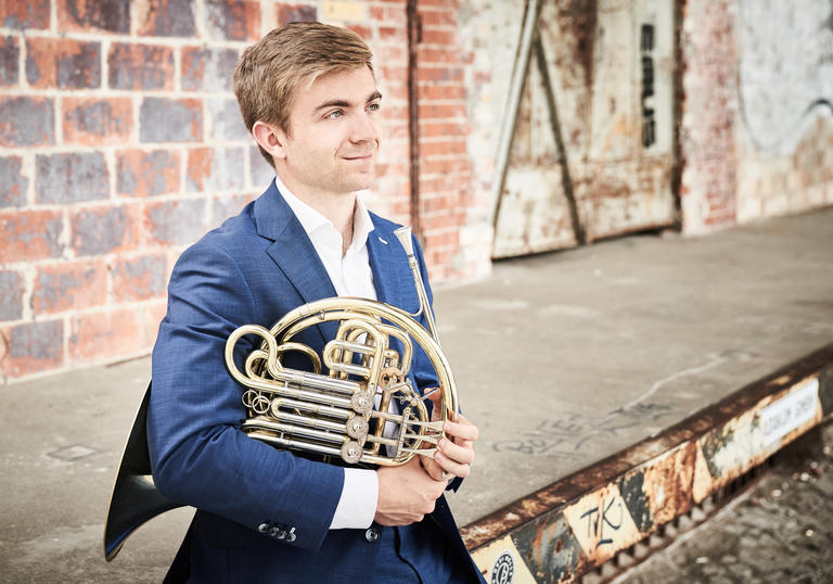 Ben Goldscheider looking into the distance with his French Horn