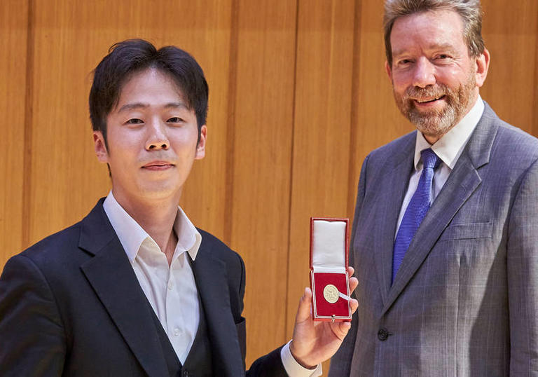 Gold Medal winner 2020 Soohong Park holding the medal next to Jonathan Vaughan