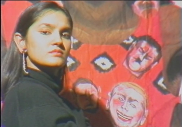 a woman looking into the camera against a colourful red background