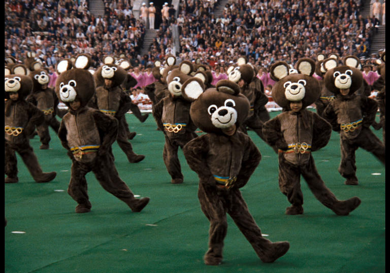 people dressed up as bears dancing in the middle of the stadium