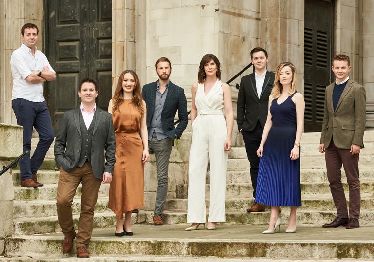 The members of Voces 8, standing on some steps