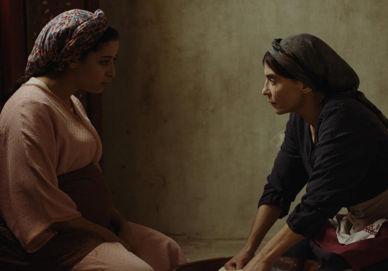 Two women sit across from each other in a still from Adam