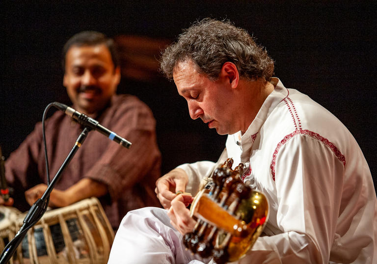 Ken Zuckerman playing the sarod with his head lowered