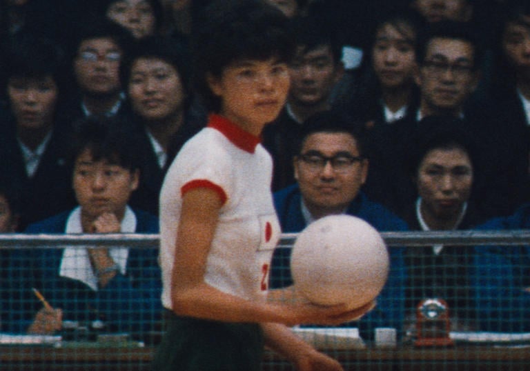 Volleyball player holding the ball in front of the crowd