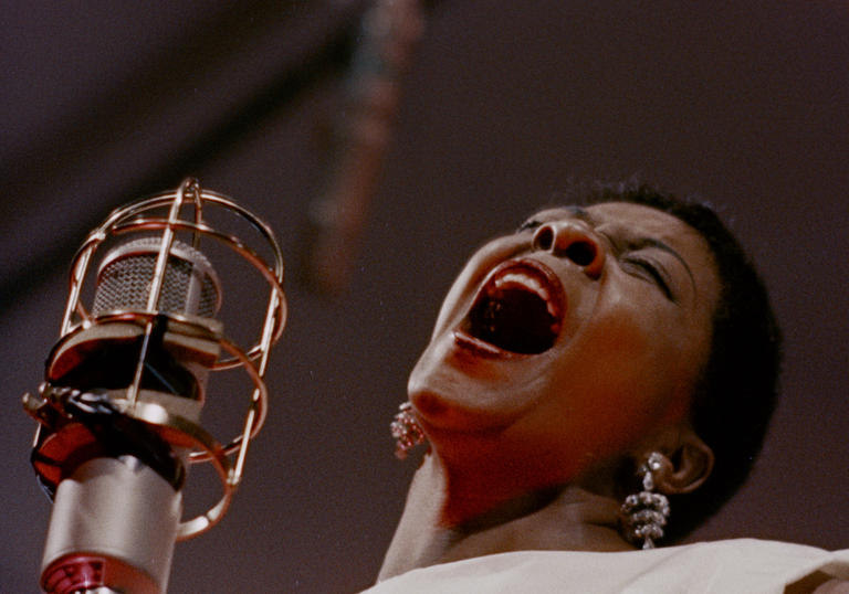 an artist sings into the mic at the Newport Jazz Festival