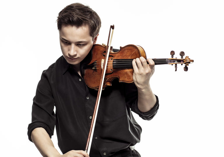 Johan Dalene plays his violin, looking down at the ground