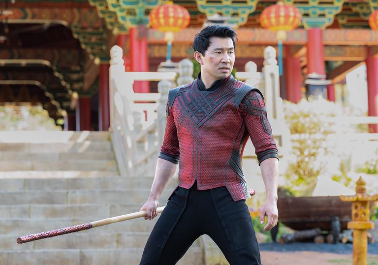 Shang-chi stands with weapon in hand