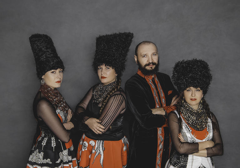 a colour photo of DakhaBrakha wearing traditional Ukrainian clothing against a plain grey backdrop