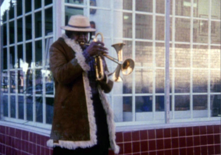 A still from When it Rains of a man playing the trumpet 